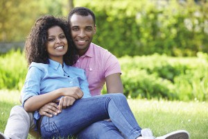 Romantic Young Couple Sitting In Garden