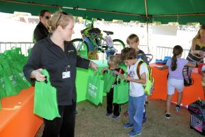 Phyllis Head, community liaison at Tanner Health System’s Get Healthy, Live Well, passes out goody bags during an event recognizing Carrollton elementary and middle school students who participated in a five-week walk/bike challenge.