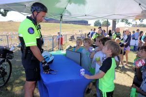 Carrollton Police Officer Michael Busch talks to students about bike helmet safety.